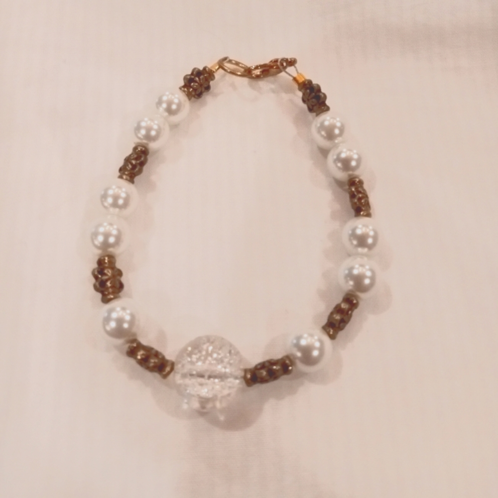 Homemade bracelet with gold lobster claw clasp. White beads & gold accent beads